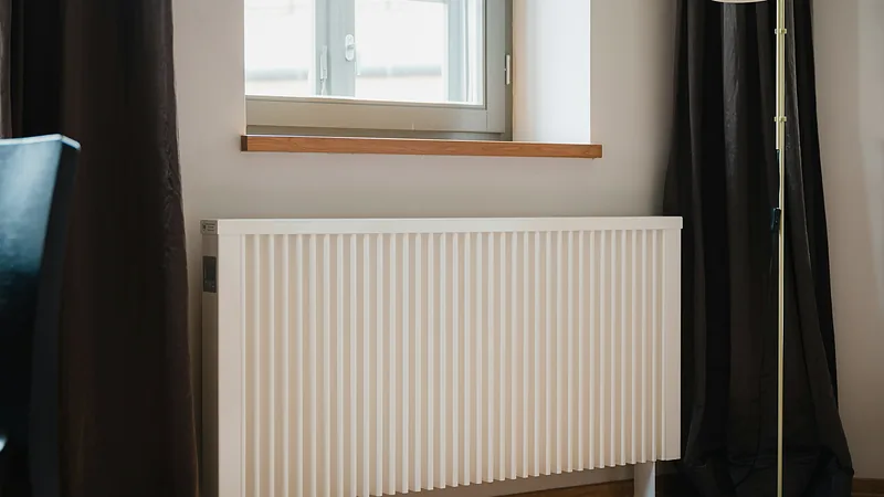 Weißer Heizkörper unter einem Fenster in einer Wohnung