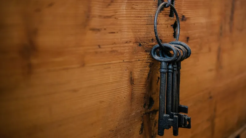 Alte eiserne Schlüssel an einem Ring, aufgehängt an einer Holzwand