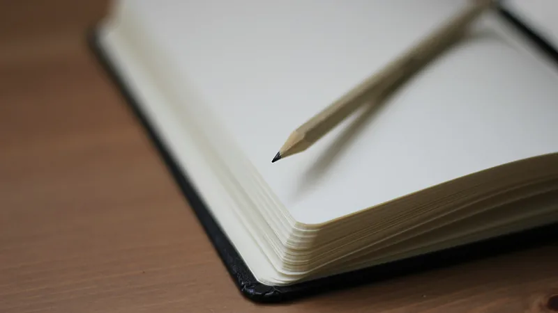 Aufgeschlagenes leeres Notizbuch mit Bleistift auf einem Holztisch